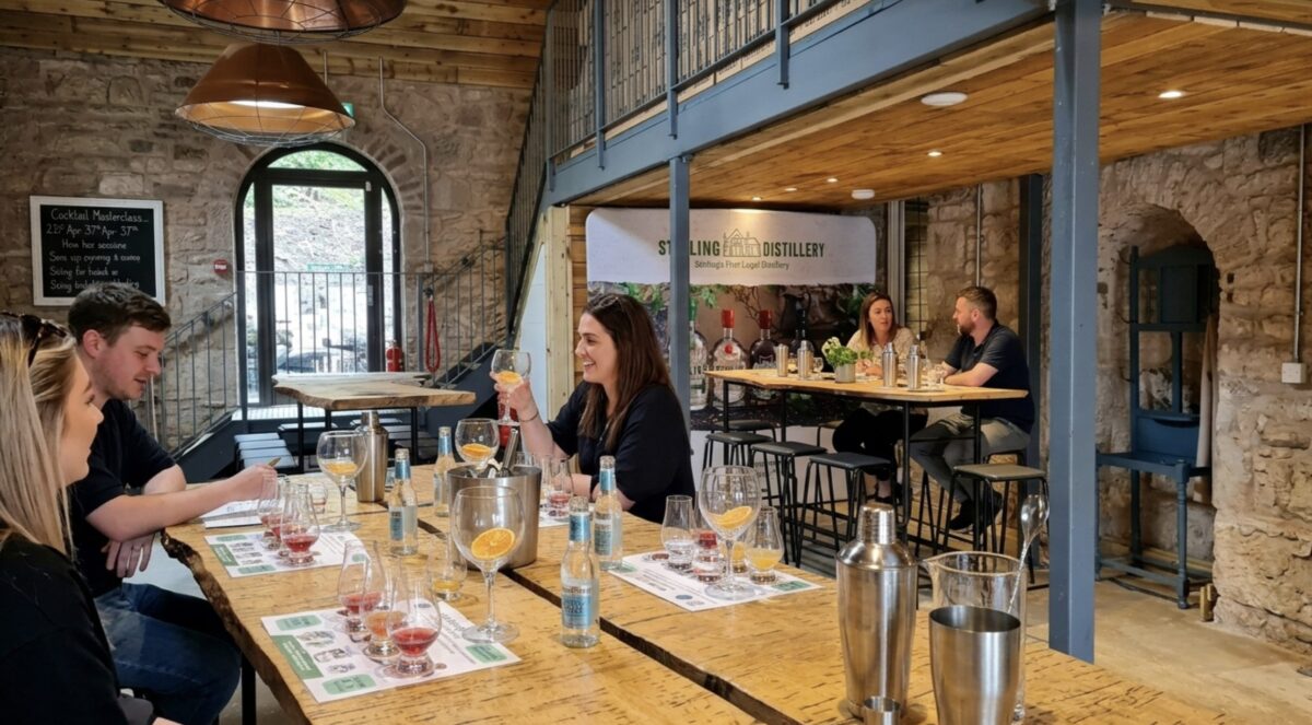 A room with people sitting on raised chairs and trying gin.